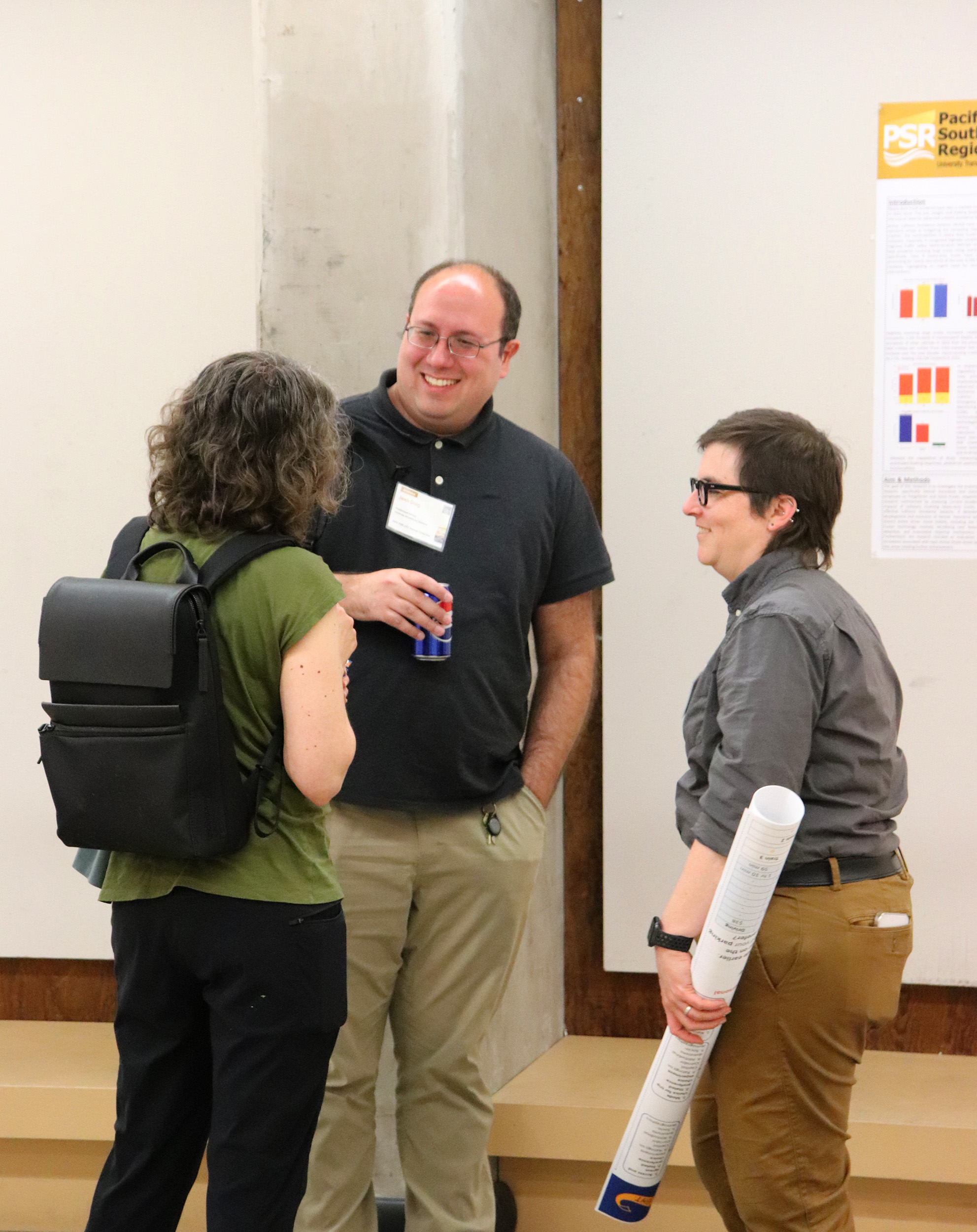 Three people standing in front of a poster