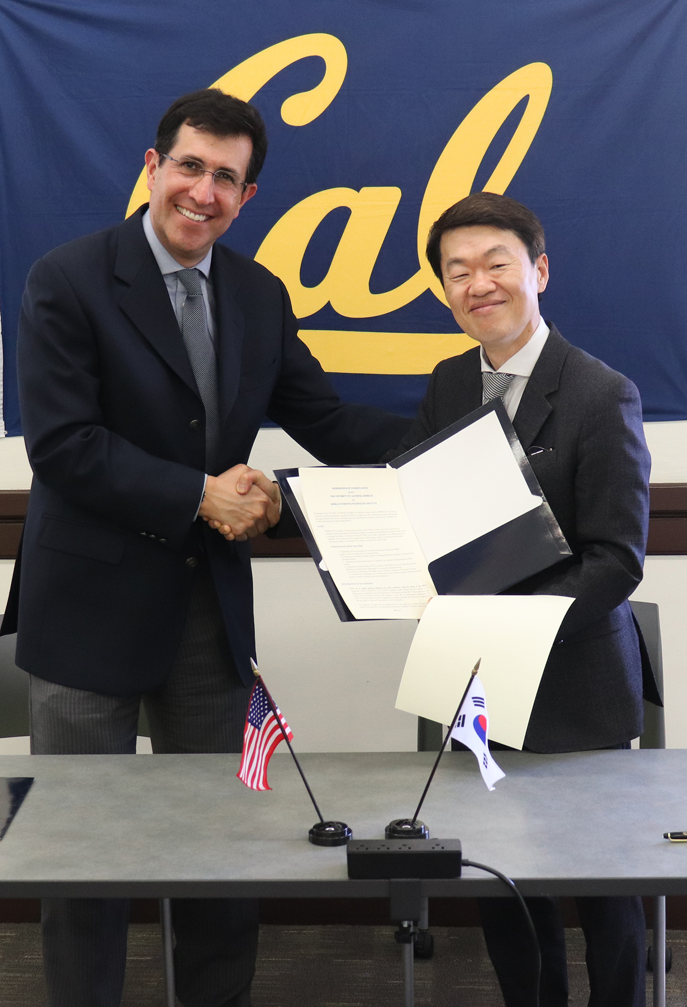 ITS Berkeley Director Daniel Rodriguez, left, and KATECH President, Mr. NA Seung Sik, right, hold up a memorandum of understanding Two men hold an MOU