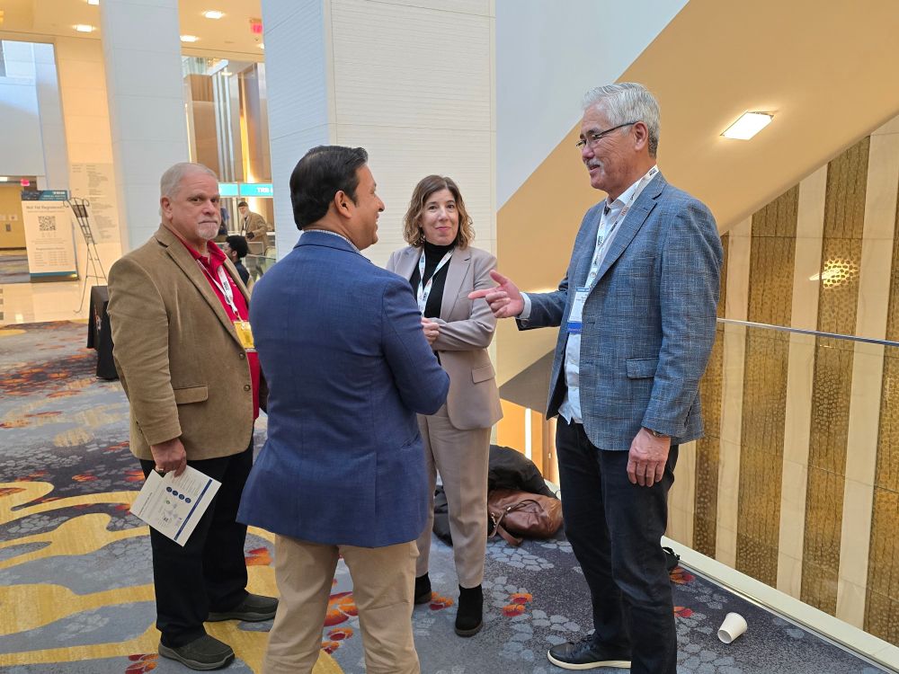 Randy Iwasaki conversing in the hallway