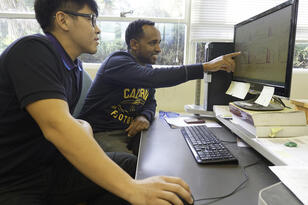 Two students working on a computer