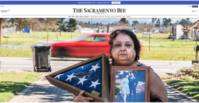 Woman holding a memorial for her father at the Sacramento Bee website
